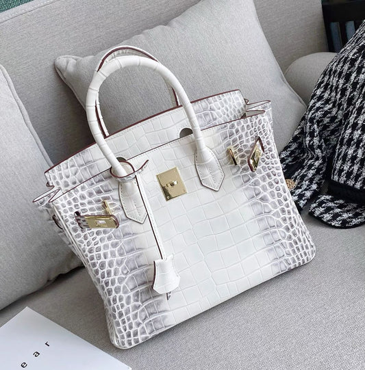 White crocodile pattern leather handbag with a gold-tone twist lock