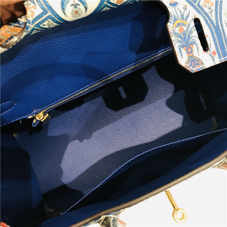 Close-up of a Birkin Handbagg with gold zipper and clasp.