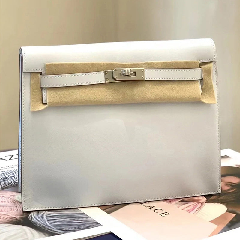 A sleek white top grain leather Kelli Danse bag with silver hardware, shown in new condition with protective felt, styled on a fashion magazine.