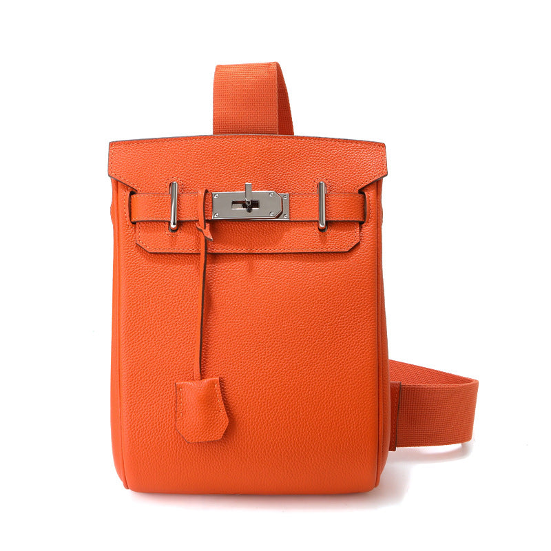 Front view of an orange Unisex Togo FannyPack crafted from pebbled top grain leather, featuring a silver turn-lock closure and a matching adjustable fabric strap.