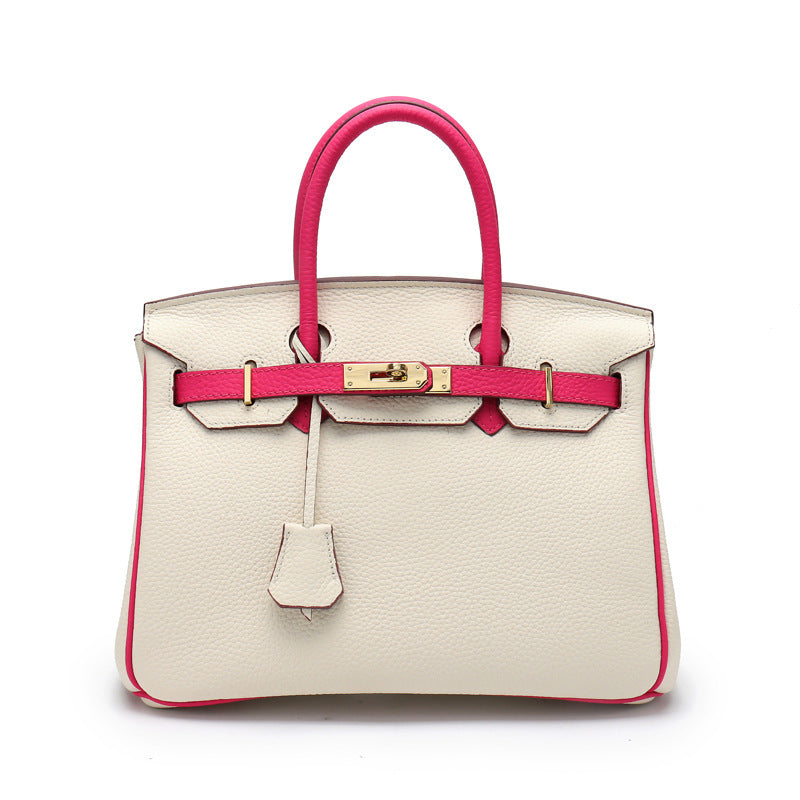 A top grain leather handbag with a classic design, featuring a gold-tone twist lock and double rolled handles.