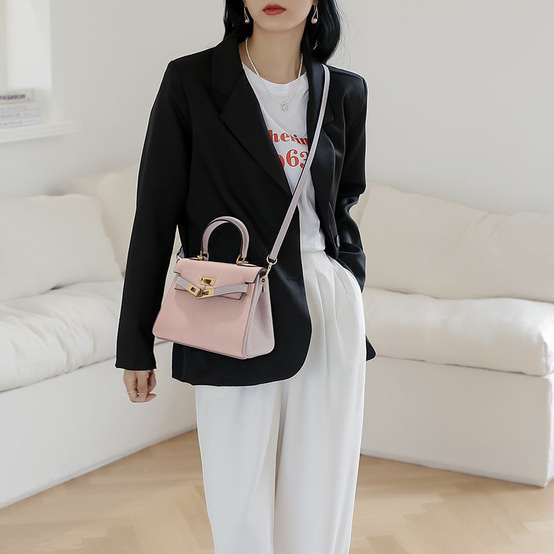 Model wearing a bi-color Rose Sakura pink and grey mini Kelly 20 bag as a crossbody bag