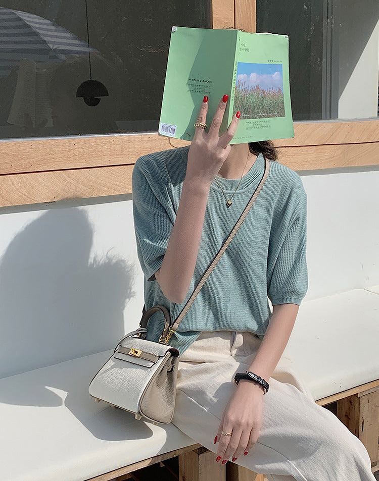 Bi-color Taupe and white mini Kelly 20 bag with gold hardware worn as a crossbody bag