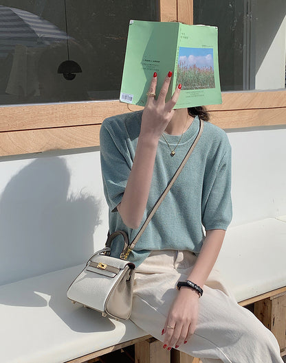 Bi-color Taupe and white mini Kelly 20 bag with gold hardware worn as a crossbody bag