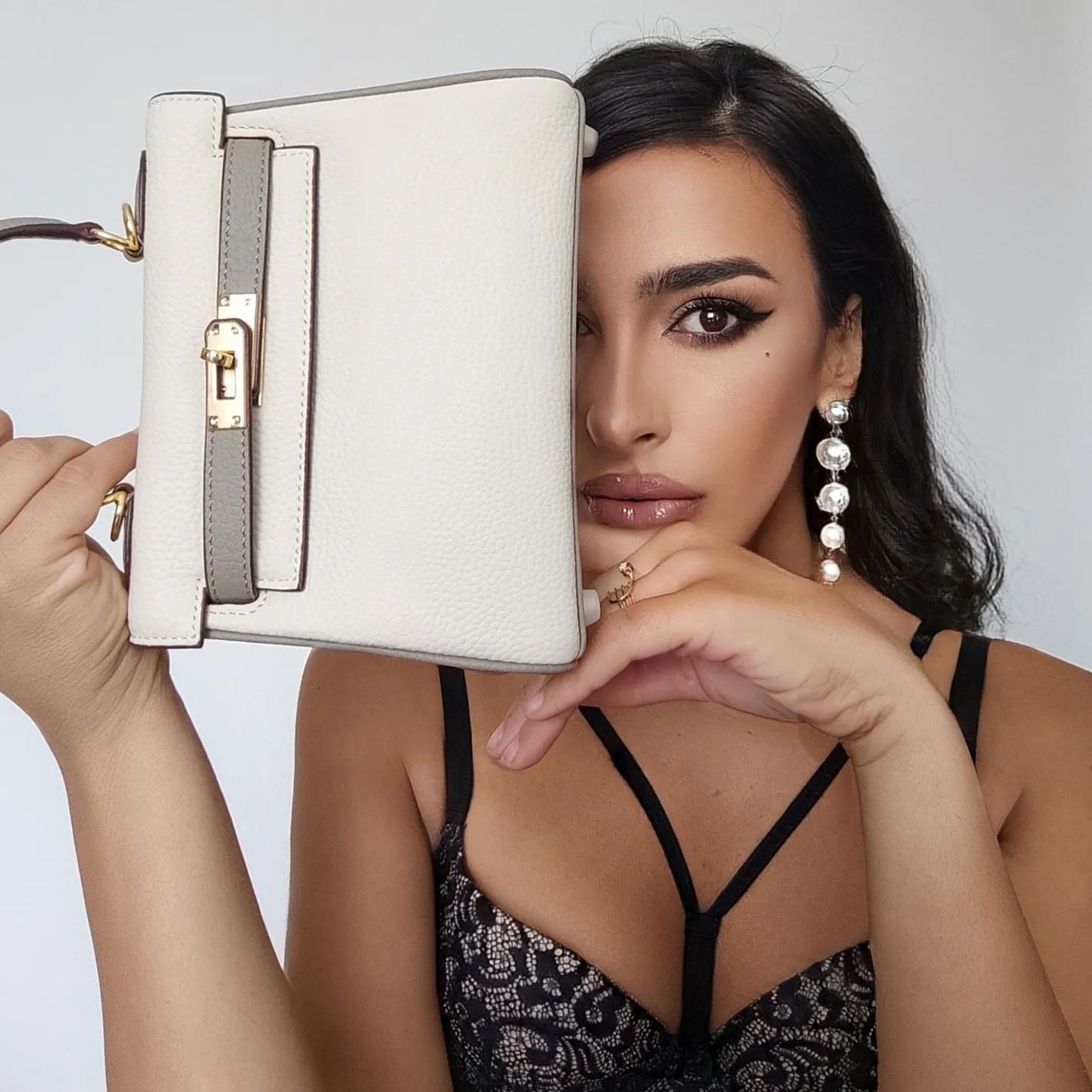 Close-up of a bi-color white and grey mini Kelly 20 bag with gold-tone hardware