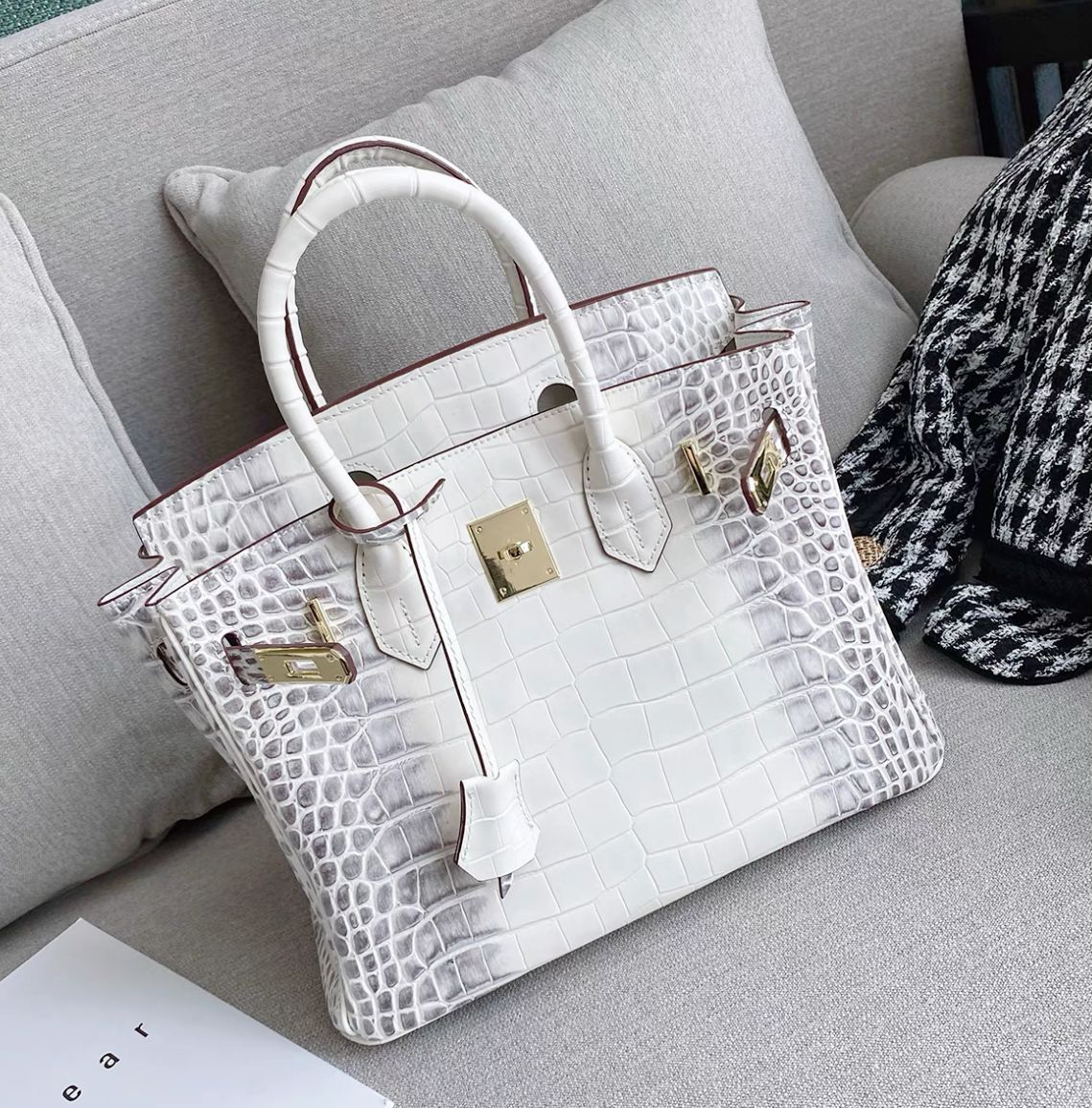 White crocodile pattern leather handbag with a gold-tone twist lock