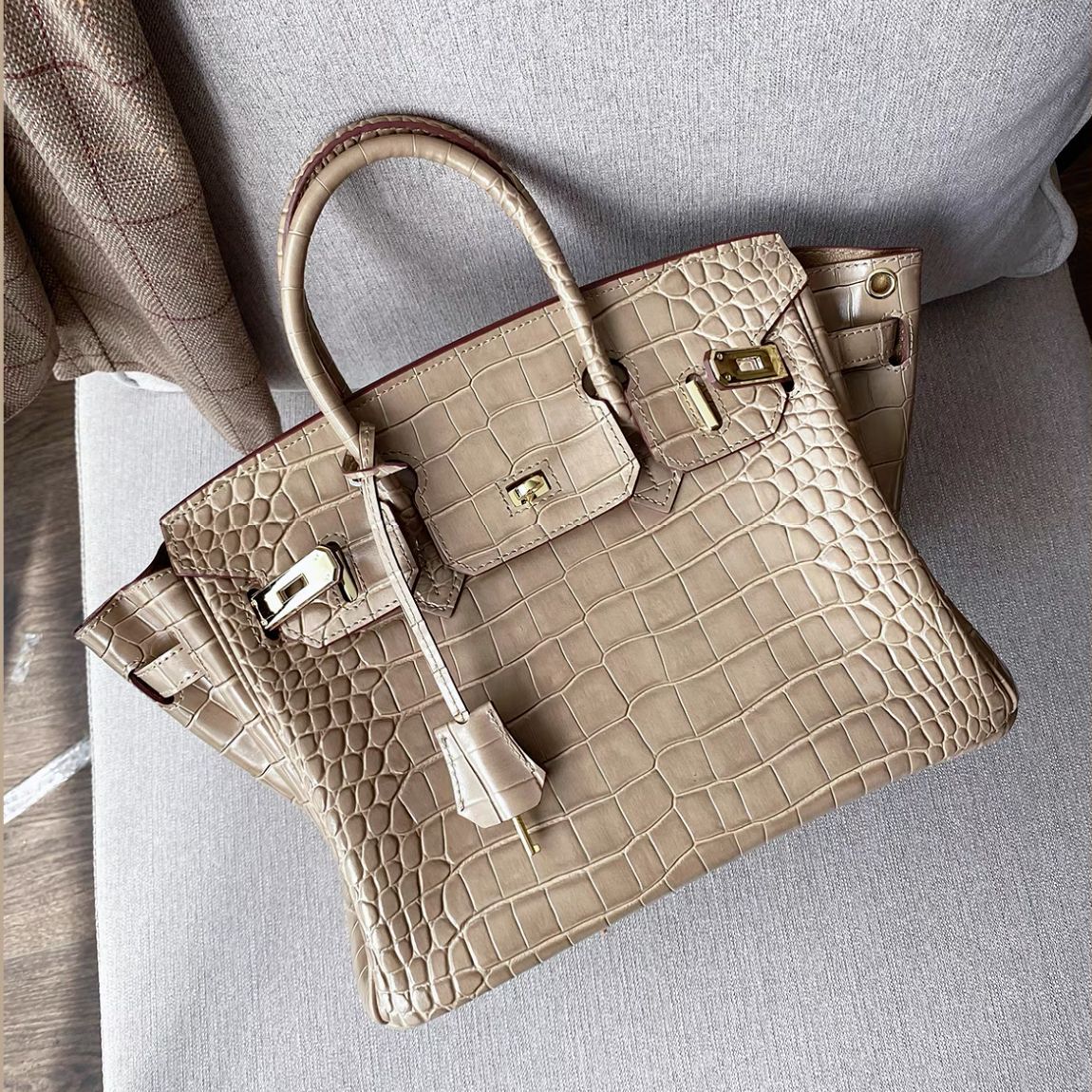 Etoupe crocodile pattern leather handbag with a gold-tone twist lock