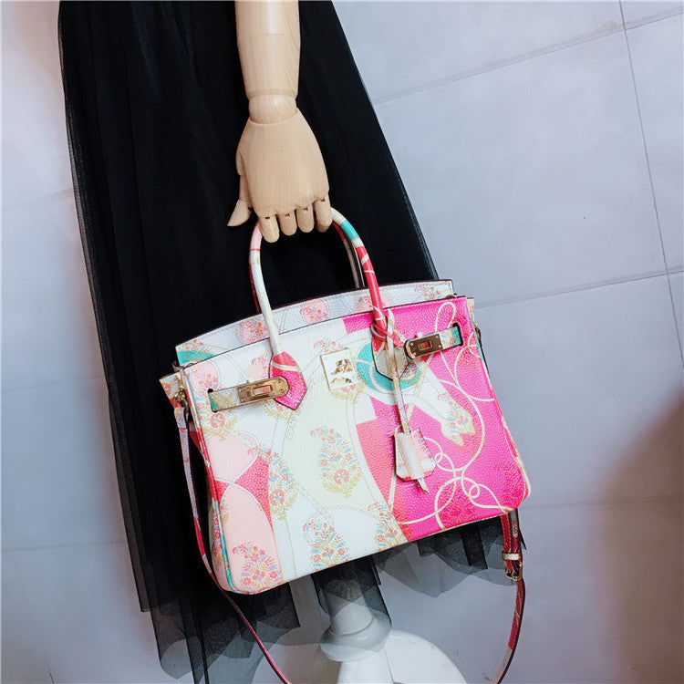 Colorful handbag held by a mannequin against a plain background