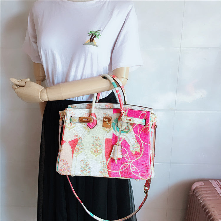 Mannequin holding a colorful handbag against a white background