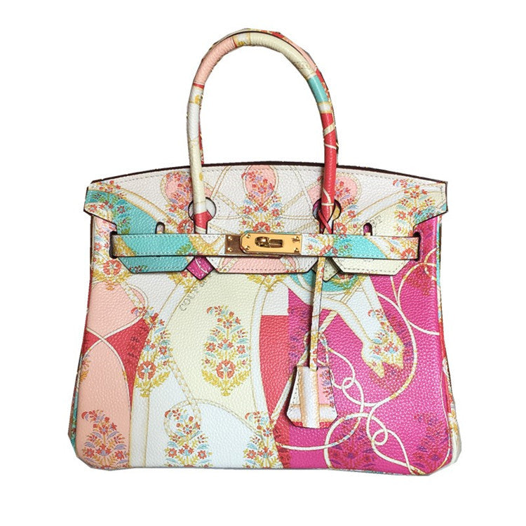 This Birkin-style bag is crafted from top-grain cowhide and features a graffiti art print and gold-tone hardware.