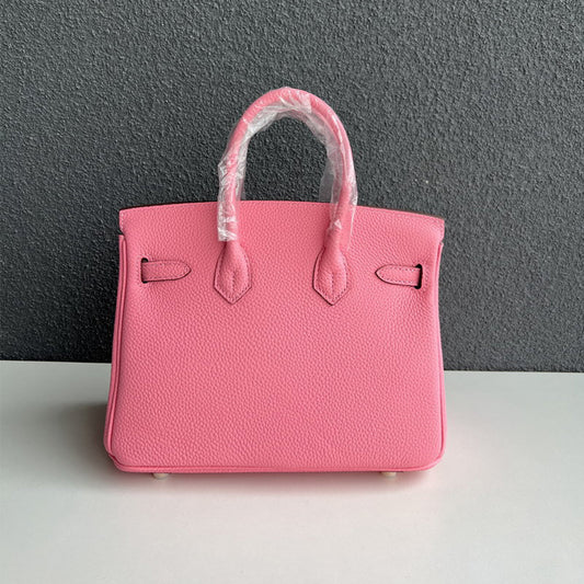 Front view of a pink Togo top-grain leather handbag with double rolled handles and iconic gold-tone twist lock, inspired by the classic Birkin design.