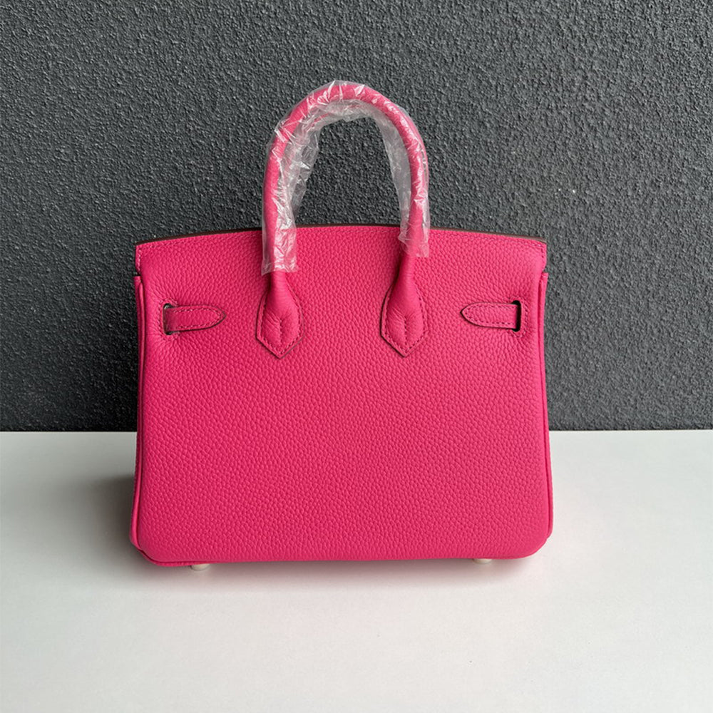 Back view of rose red leather handbag with double rolled handles.
