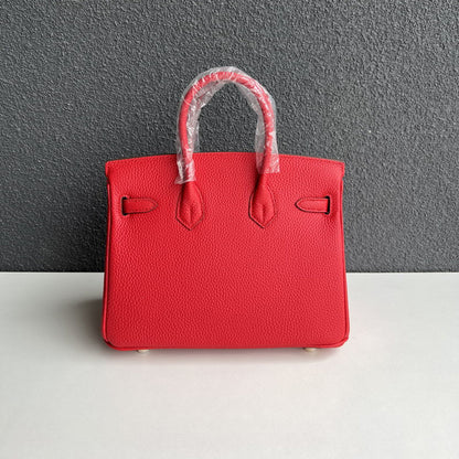 Back view of red genuine leather handbag with double rolled handles.