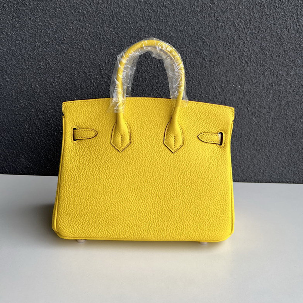 Back view of yellow genuine leather handbag with double handles.