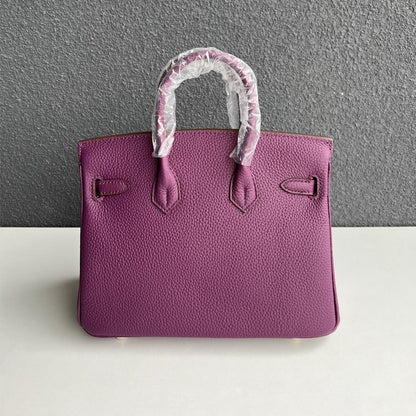 Back view of purple genuine leather handbag with double rolled handles.
