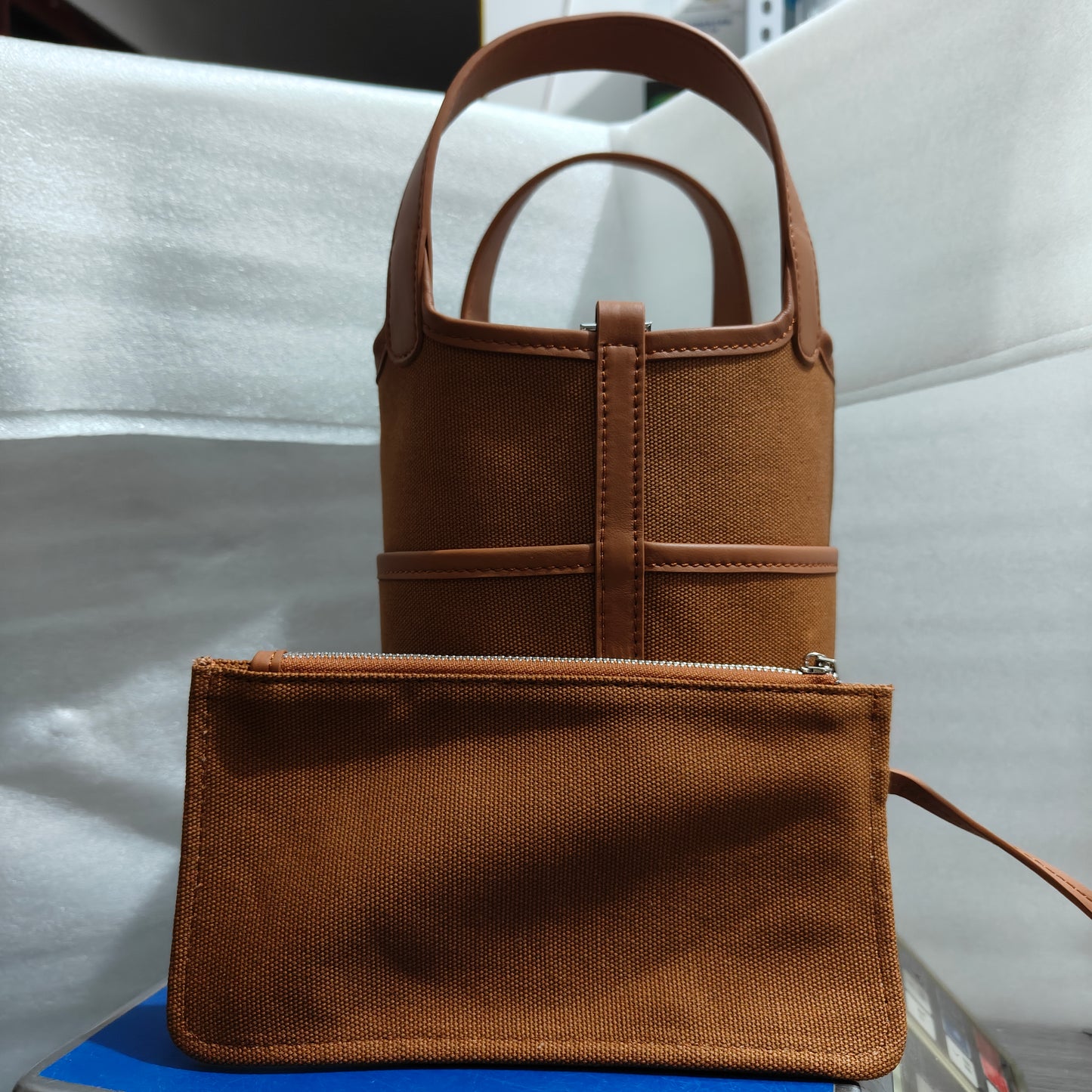 Detail view of a brown Cargo Pictin 18 handbag with a matching canvas zipper pouch, highlighting the textured leather and canvas material.