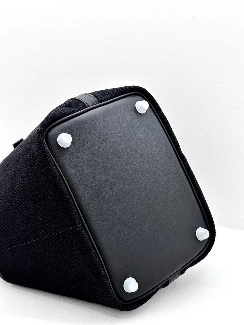 Bottom view of a black Cargo Pictin 18 handbag featuring four protective metal feet and premium smooth leather base.