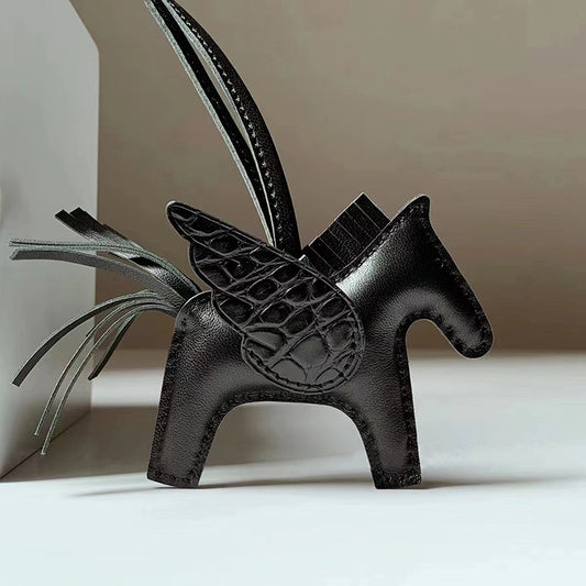 Black lambskin Pegasus horse bag charm with crocodile pattern wings and leather strap.