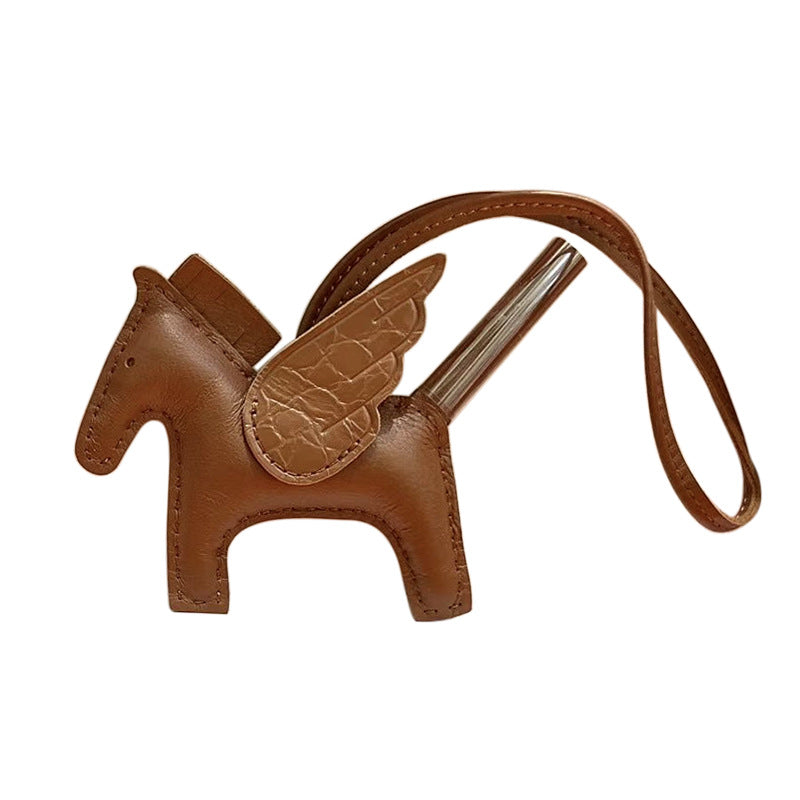 Tan lambskin Pegasus charm with brown crocodile-pattern wings and leather strap.