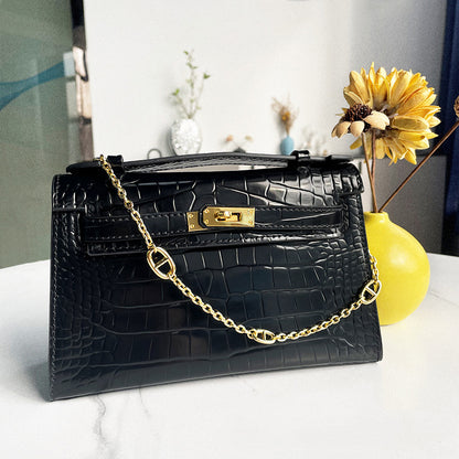 Black crocodile embossed leather Kelli clutch bag with gold chain and hardware.