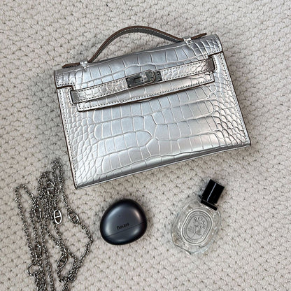 Silver crocodile embossed leather Kelli clutch bag with chain strap and silver hardware.