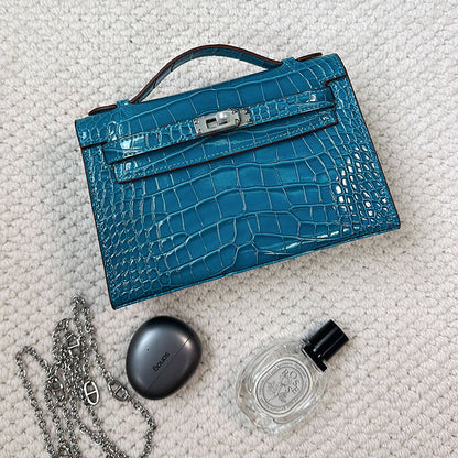 Blue crocodile embossed leather Kelli clutch bag with chain strap and silver hardware.