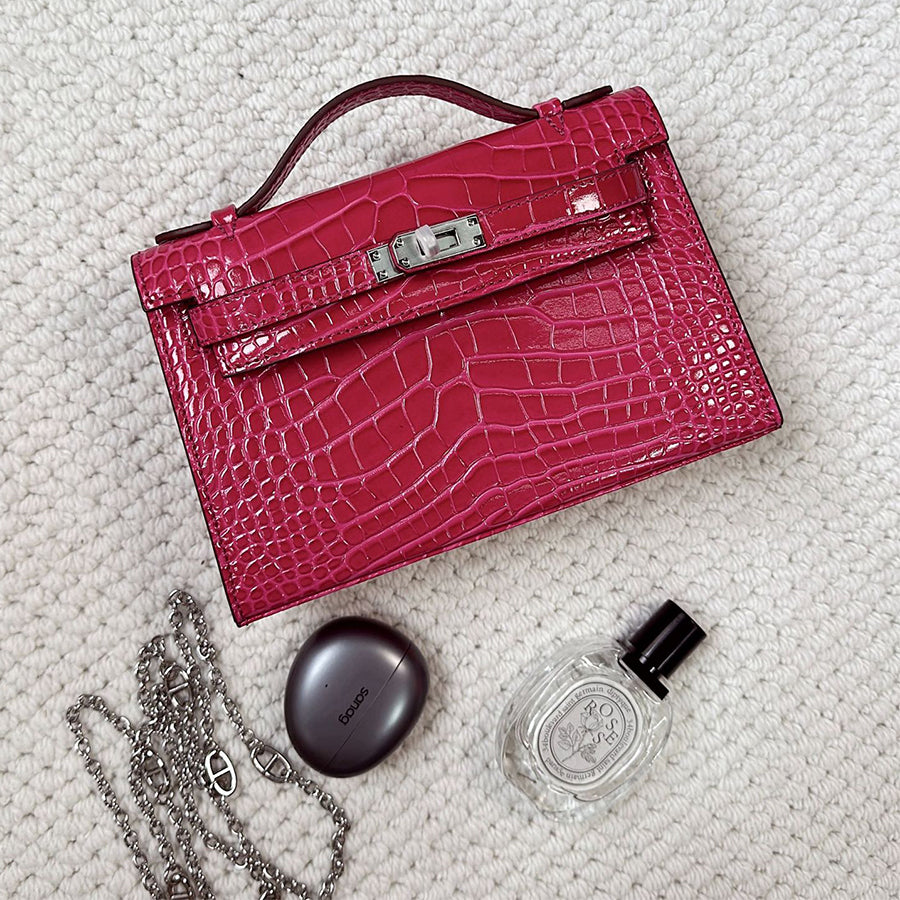 Rosy crocodile embossed leather Kelli clutch bag with chain strap and silver hardware.