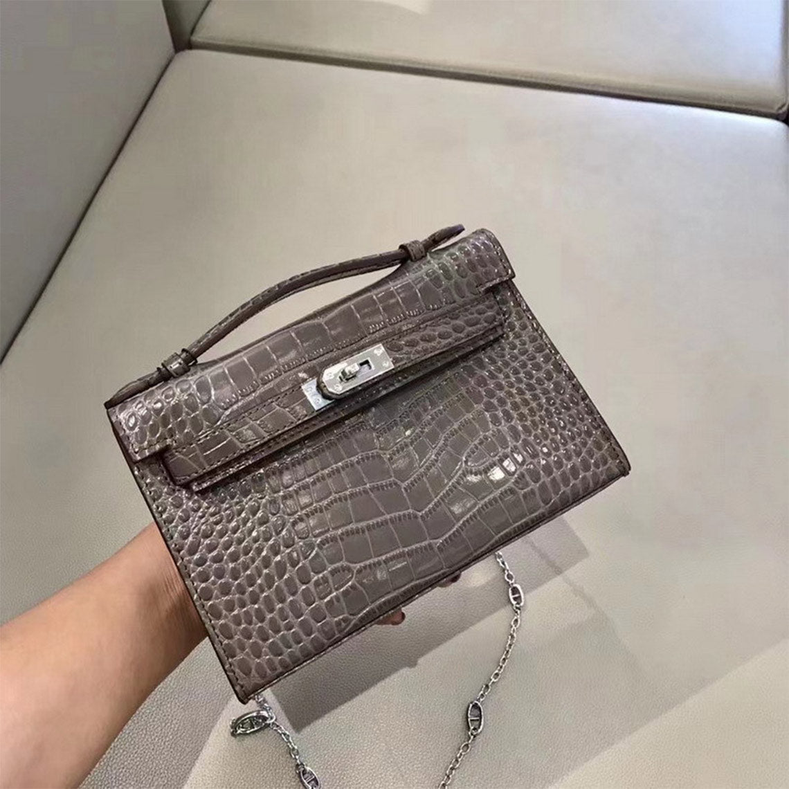 Grey crocodile embossed leather Kelli clutch bag with silver chain strap.