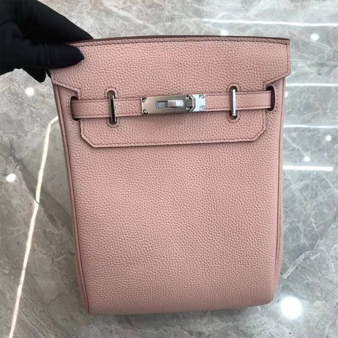 Pink leather designer crossbody bag with silver hardware and a canvas strap.