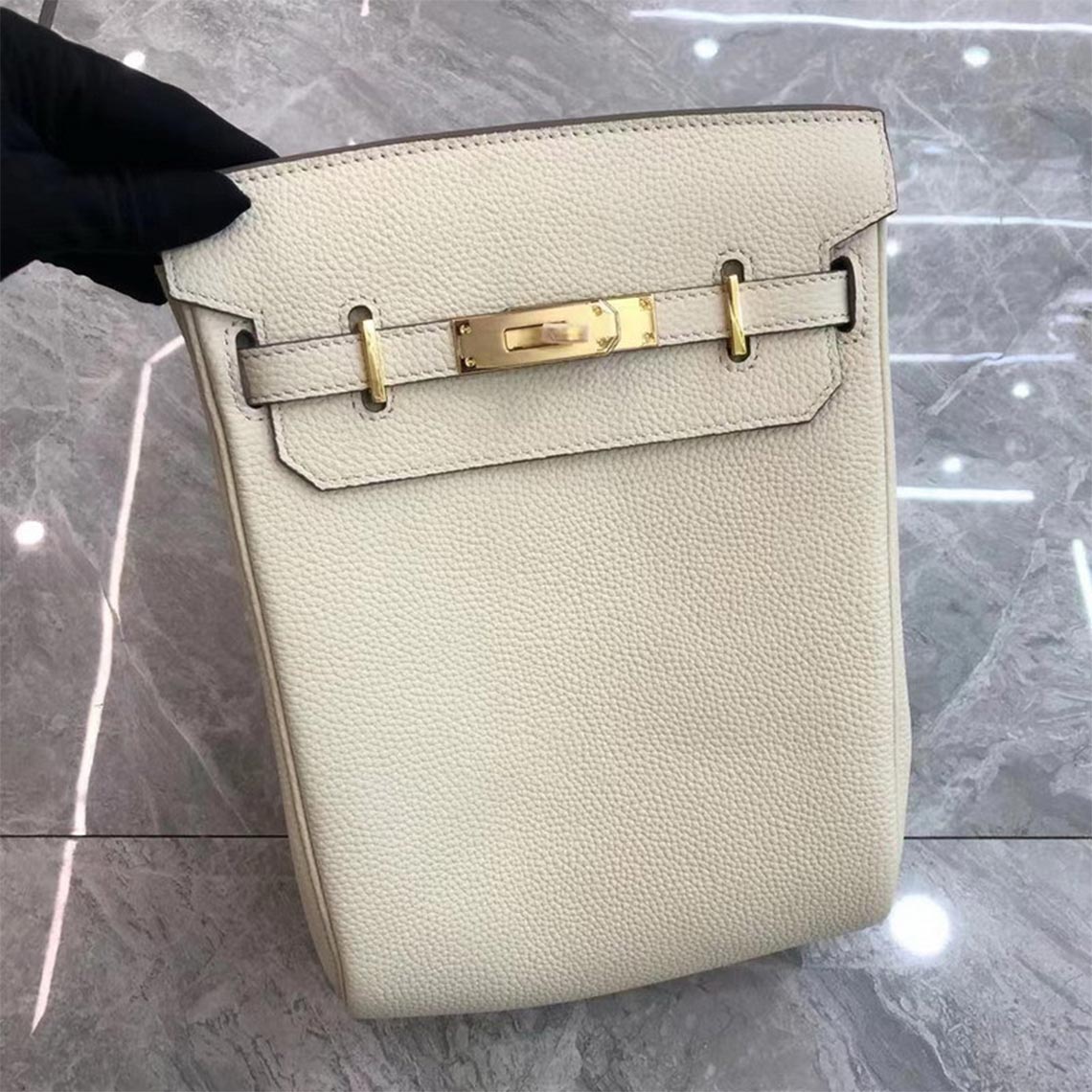 White leather designer crossbody bag with silver hardware and a canvas strap.