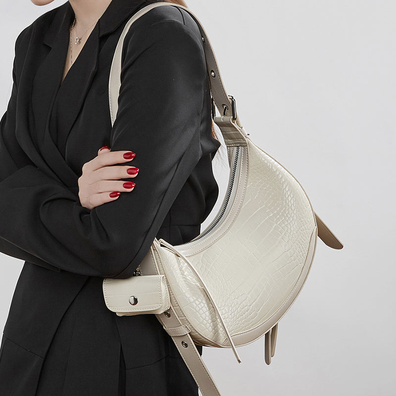 Off-white Crocodile-embossed texture accented with studs, featuring a shell-shaped silhouette.