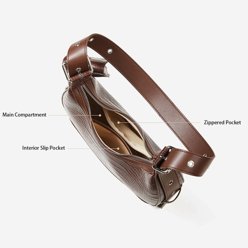A top-down view of a brown crocodile-embossed leather bag, showcasing its multi-layered interior: featuring a main compartment, a zippered pocket, and an interior slip pocket.