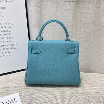 Back view of a blue mini Kelli handbag in premium top grain leather, showing the structured silhouette and sturdy top handle.
