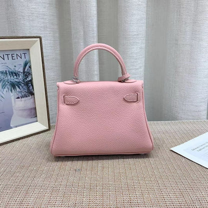 Back view of a pink mini Kelli handbag crafted from top grain pebbled leather, highlighting its elegant trapezoidal shape and top handle.