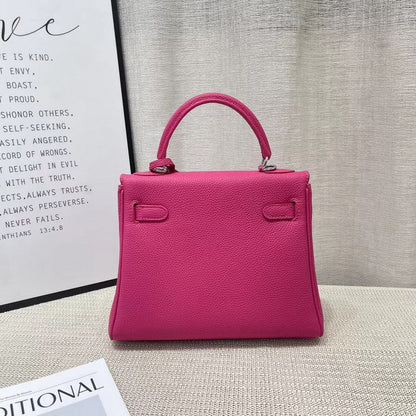 Back view of a vibrant rose red mini Kelli handbag in premium top grain pebbled leather with a classic top handle.