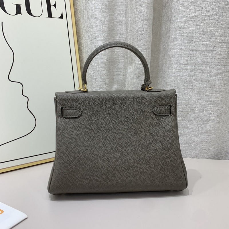 Back view of a mini Kelli handbag in Gris Etain top grain pebbled leather, featuring gold-tone hardware accents and a structured silhouette.