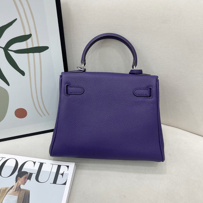 Back view of a luxury dark purple mini Kelli handbag in premium top grain pebbled leather, featuring a classic top handle and silver-tone hardware details.