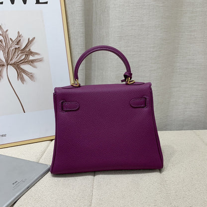 Back view of a mini Kelli handbag in Anemone purple top grain pebbled leather, featuring gold-tone hardware and a structured trapezoidal shape.