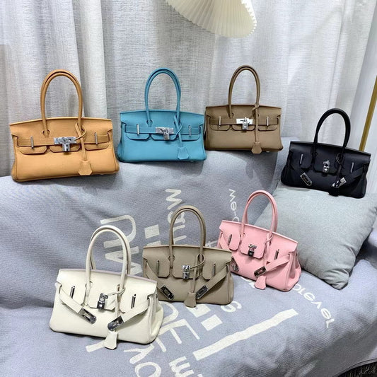 A collection of inspired JPG Birkin handbags in seven colors, including tan, sky blue, taupe, black, beige, and pink, all crafted from high-quality top grain cowhide leather.