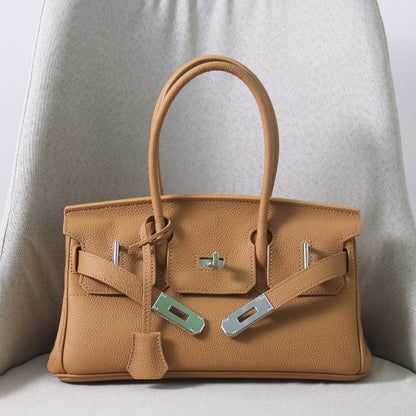 Front view of a tan JPG Birkin inspired handbag in textured top grain cowhide leather, showcasing its classic lock closure and 14cm top handles.