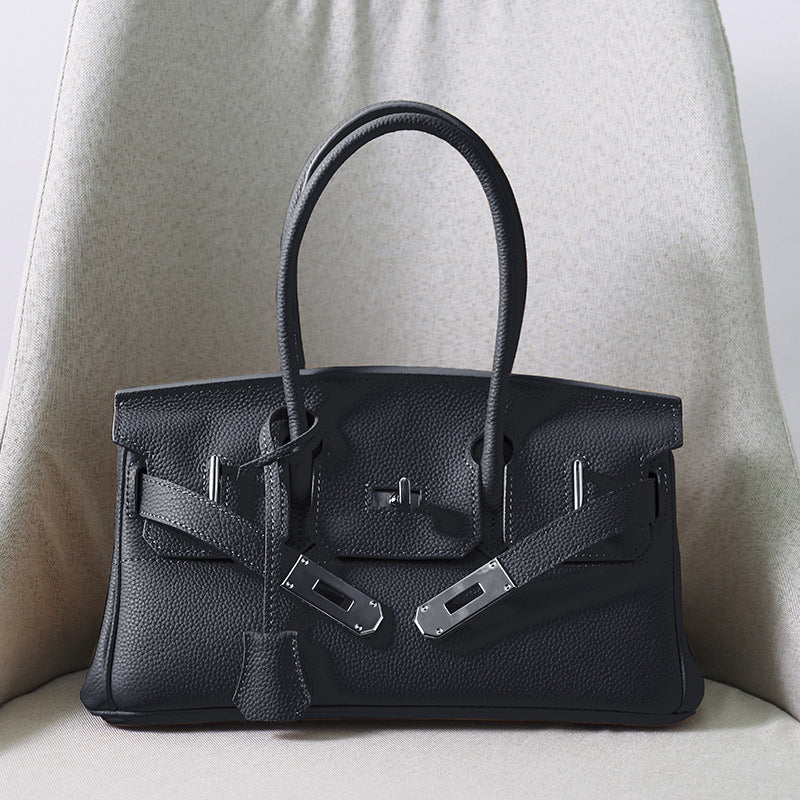 Front view of a classic So Black JPG Birkin inspired handbag in textured top grain cowhide leather, featuring silver-tone lock closure hardware and a matching clochette.