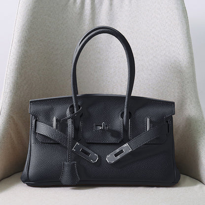 Front view of a classic So Black JPG Birkin inspired handbag in textured top grain cowhide leather, featuring silver-tone lock closure hardware and a matching clochette.
