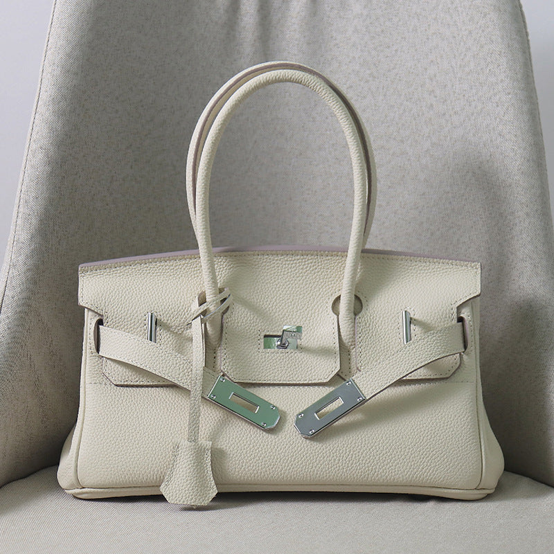 Front view of a Off-white JPG Birkin inspired handbag in textured top grain cowhide leather, featuring silver-tone lock closure hardware and a matching clochette.