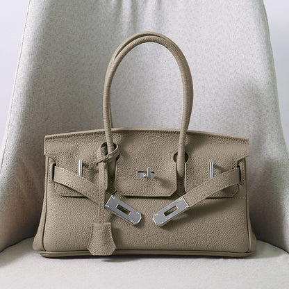 Front view of a Gray JPG Birkin inspired handbag in textured top grain cowhide leather, featuring silver-tone lock closure hardware and a matching clochette.