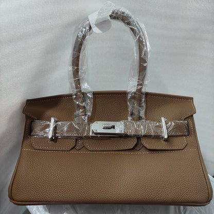 Front view of a Khaki JPG Birkin inspired handbag in textured top grain cowhide leather, featuring silver-tone lock closure hardware and a matching clochette.
