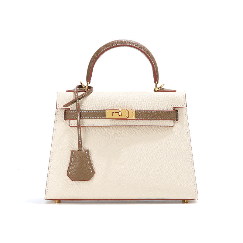  Elegant bi-color leather Kelli handbag featuring a classic top-handle design and gold-tone hardware.