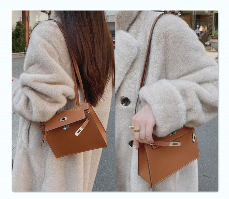 A gold-brown top-grain cowhide Kelli Danse bag, elegantly styled, is worn as a shoulder bag tucked beneath the arm, paired with a long-pile beige faux fur coat.