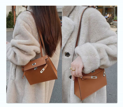 A gold-brown top-grain cowhide Kelli Danse bag, elegantly styled, is worn as a shoulder bag tucked beneath the arm, paired with a long-pile beige faux fur coat.