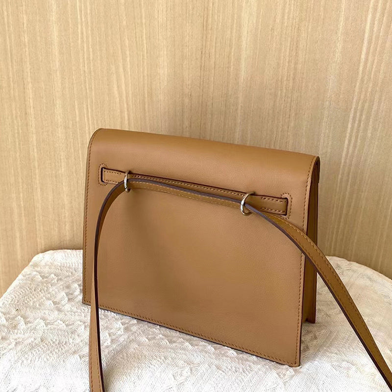 Back view of a Golden Brown top grain leather Kelli Danse bag, showing the adjustable strap threaded through leather loops for multiple carrying options.