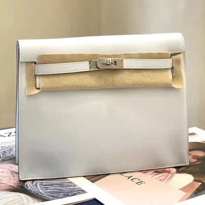 A sleek white top grain leather Kelli Danse bag with silver hardware, shown in new condition with protective felt, styled on a fashion magazine.